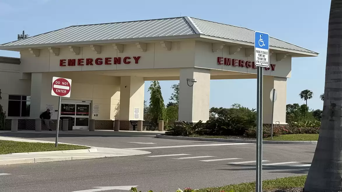Emergency room entrance of a hospital with handicapped parking in the foreground.