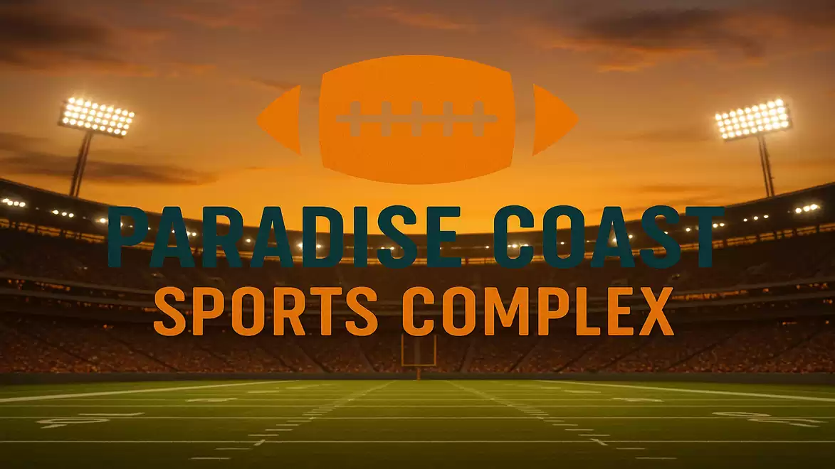 A football stadium at sunset with the words 'Paradise Coast Sports Complex' in the foreground.