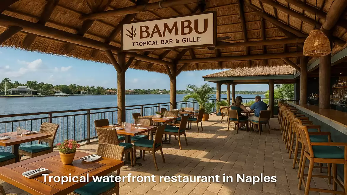 A tropical waterfront restaurant in Naples with a thatched roof and open view of the water.