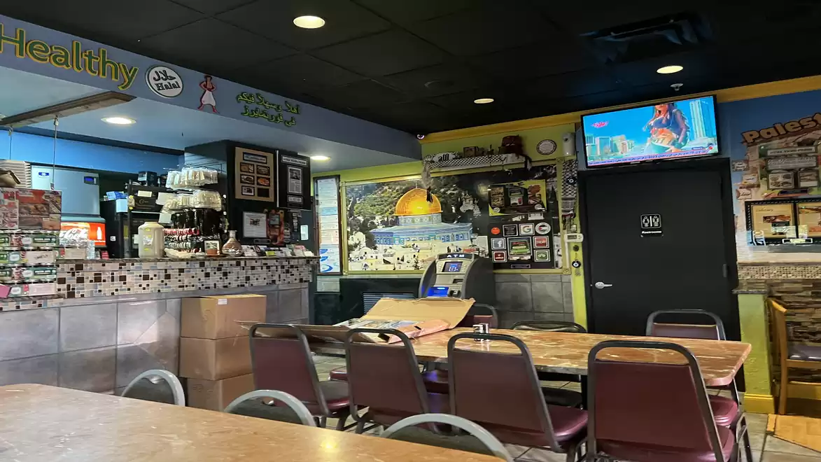 A cozy interior view of a diner with empty tables and a TV playing on the wall.