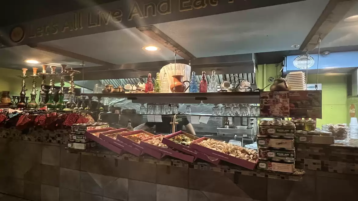 A market stall with various spices and decorative items. In the background, shelves with glassware and packages are visible.