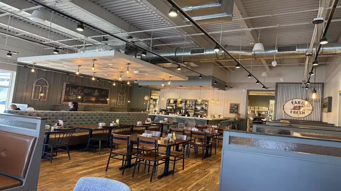 Modern restaurant interior with wooden floors and industrial design.
