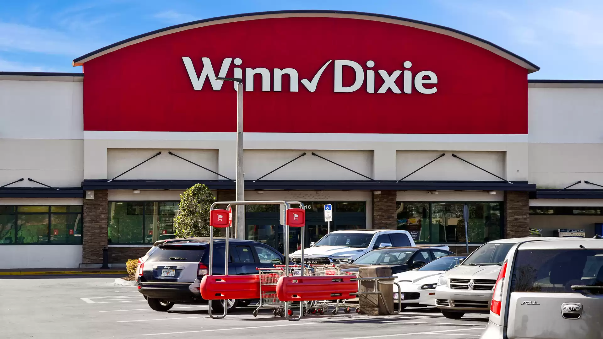 Winn-Dixie supermarket with parking lot and shopping carts in the foreground.