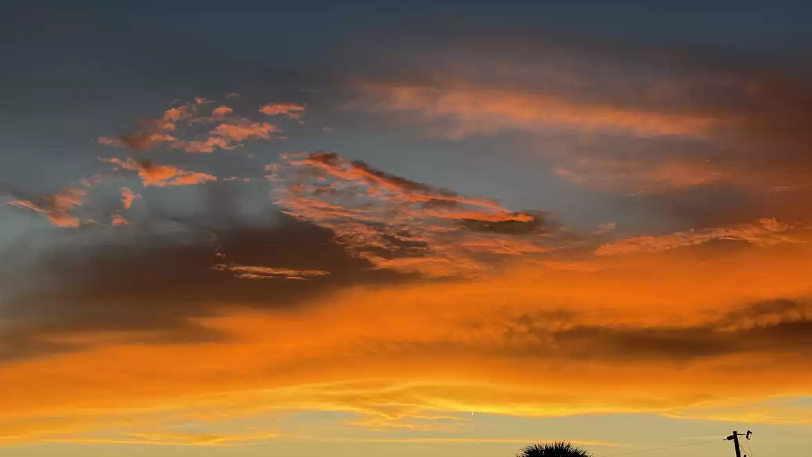 Evening sky with dramatic orange and blue cloud formations at sunset.