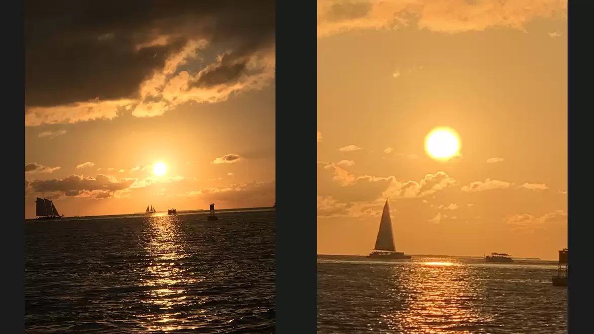 Two sailboats on a calm sea at sunset, the sun casting warm orange hues on the water.