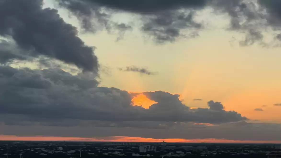 A stunning sunset on the horizon with dramatic cloud formations covering the sky.