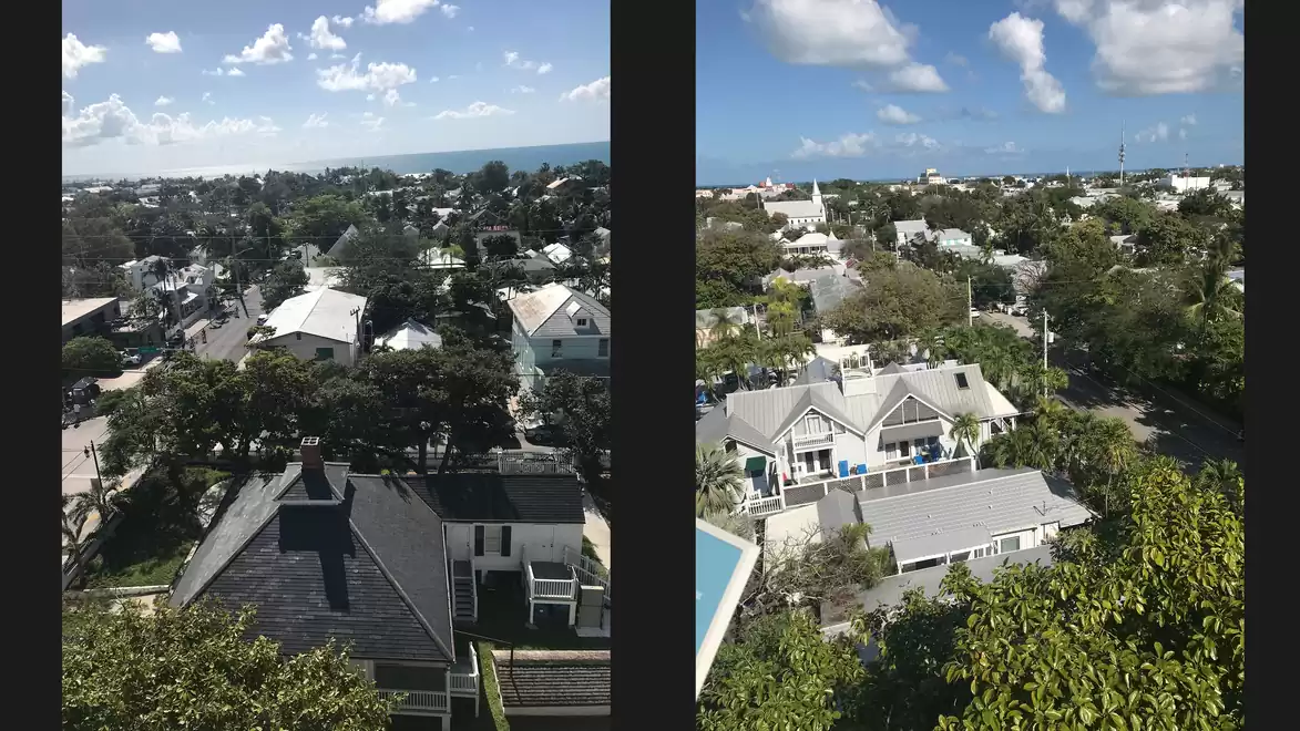 Panoramic view of a coastal town with blue sky and scattered clouds.
