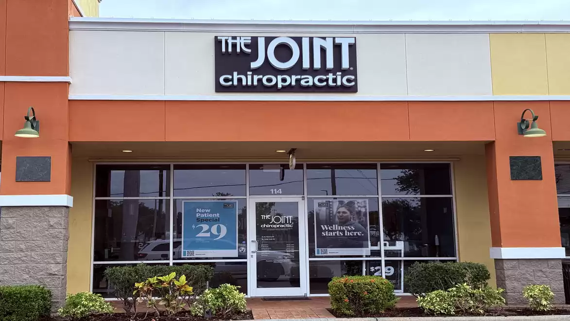 Exterior view of a chiropractic clinic named 'The Joint' in a modern commercial building.