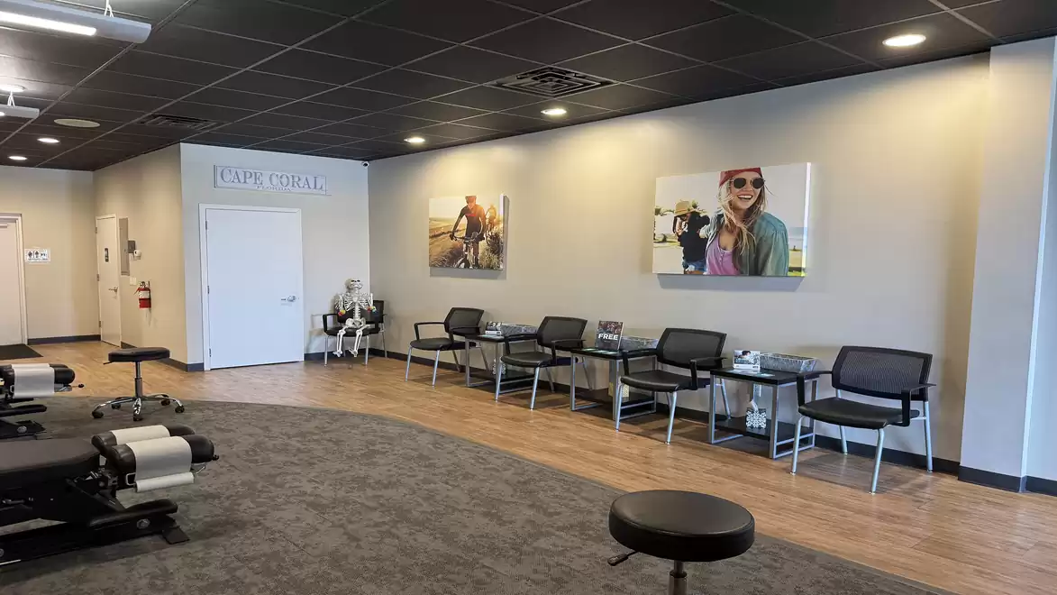 Interior view of a modern waiting room with chairs, wall art, and a table in a doctor's office.