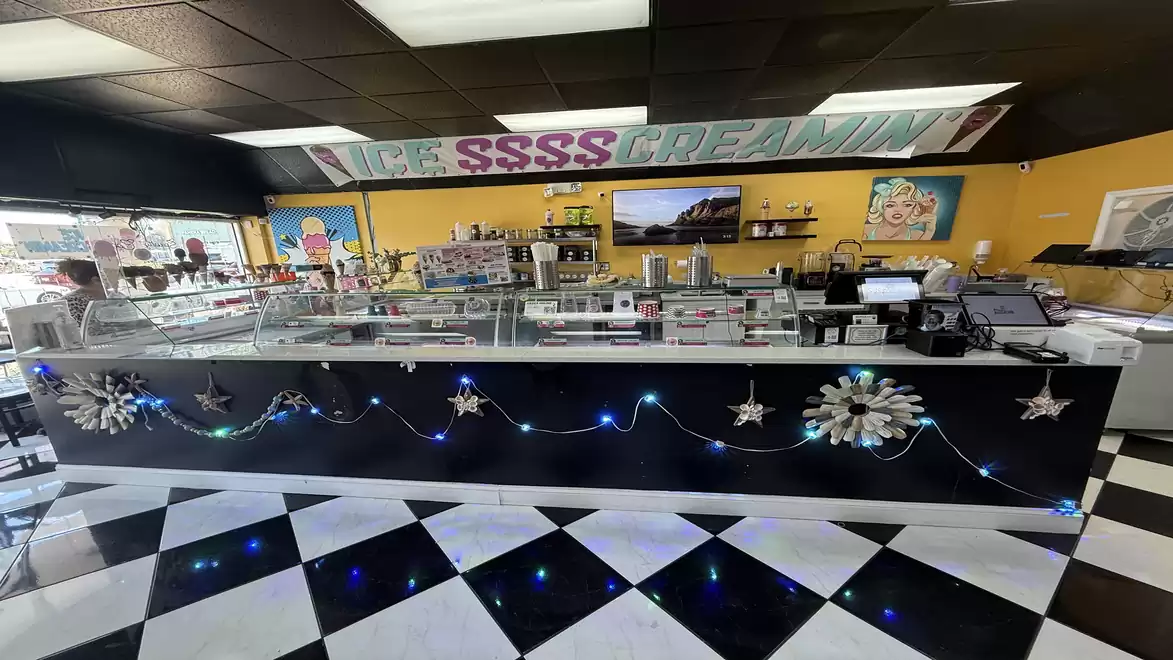 Interior of an ice cream shop with a decorated counter and checkered floor.