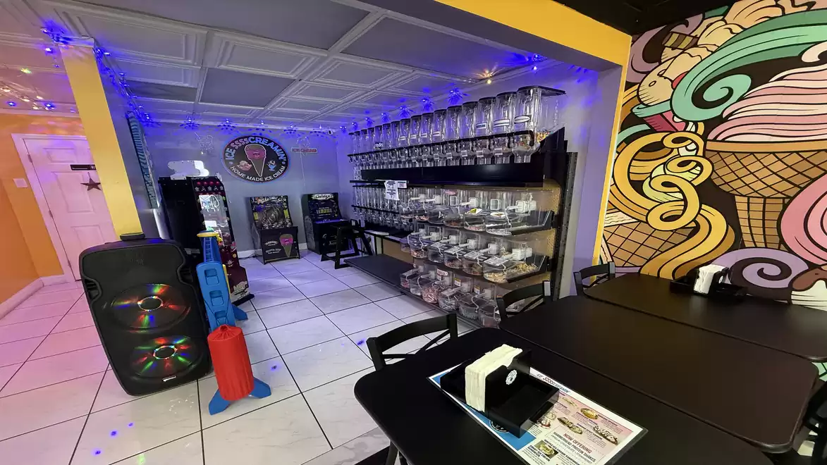 Interior of a modern café with colorful murals, decorative lights, and counters filled with coffee and tea accessories.
