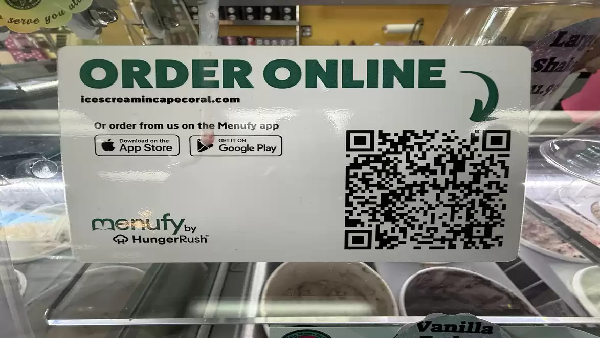 Sign in an ice cream shop prompting 'Order Online' with a QR code for scanning. The website icecreamincapecoral.com is mentioned. Menufy apps are also listed.