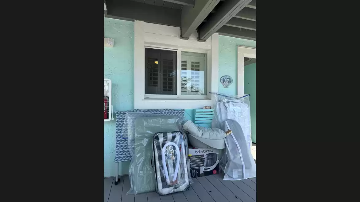 Pile of trash and a baby playpen on a porch.