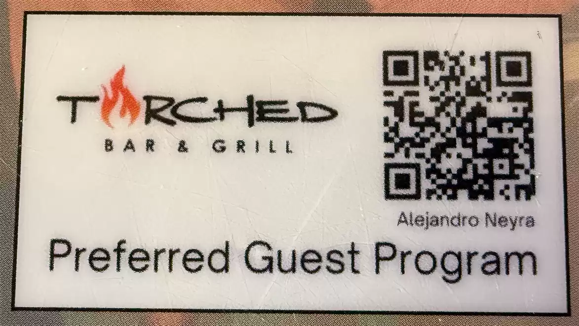 The image shows a card for the Torched Bar & Grill Preferred Guest Program with a QR code.