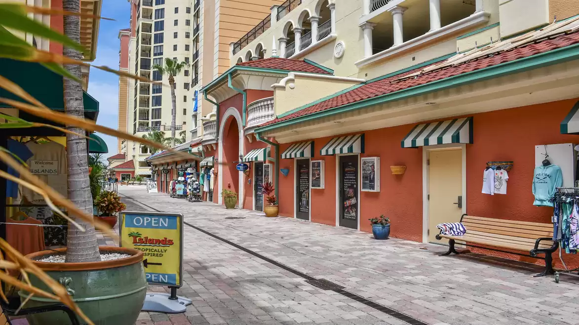 A charming shopping arcade with colorful buildings and shops inviting exploration. Some signs indicate that shops are open.