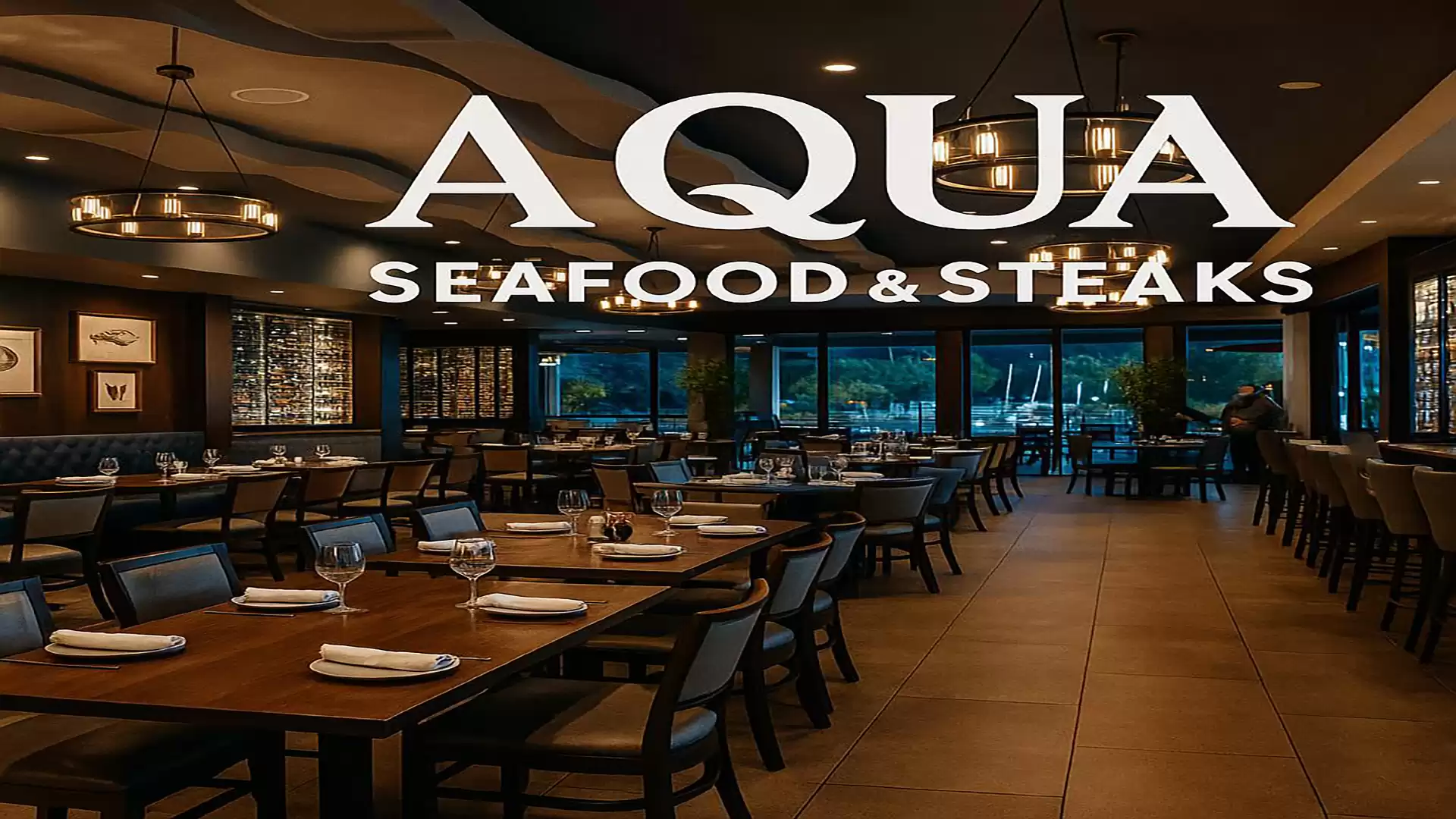 Interior of an elegant restaurant named Aqua Seafood & Steaks with set tables and modern lighting.