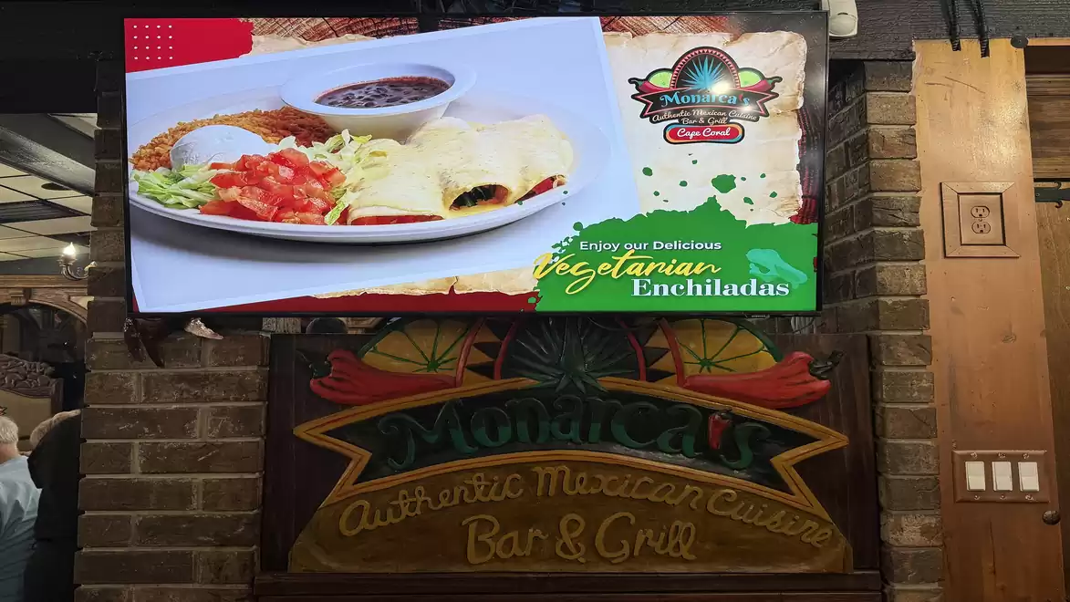 Advertisement for vegetarian enchiladas in a Mexican restaurant, featuring a plate of stuffed enchiladas and sides.