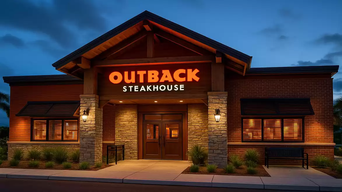 Exterior view of an Outback Steakhouse at dusk with illuminated sign and inviting atmosphere.