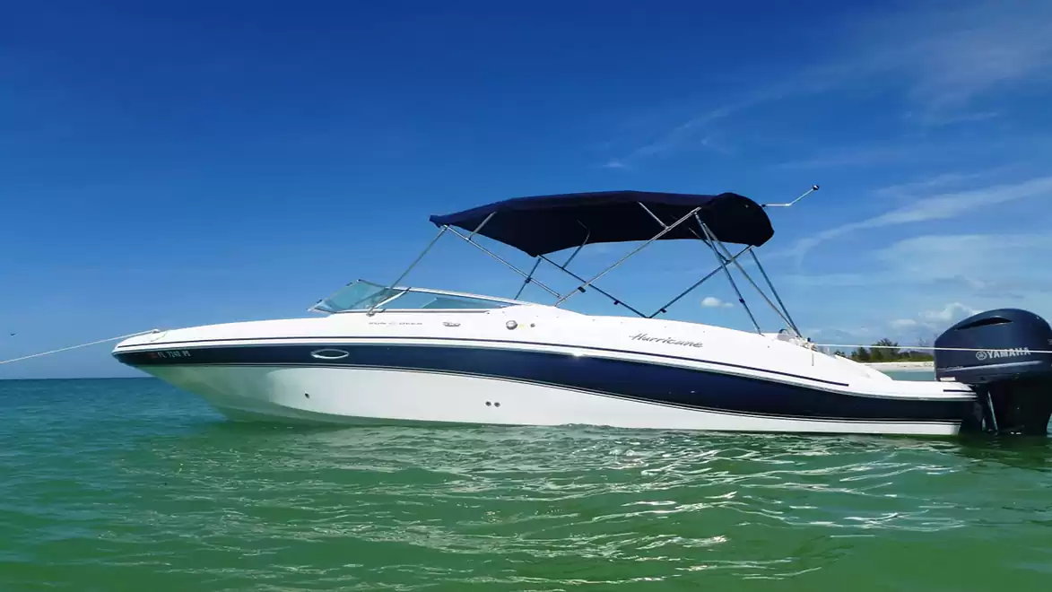 Motorboat on calm water with blue sky.