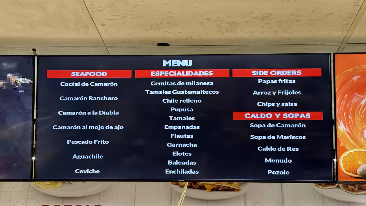 Image of a restaurant menu on a screen with different categories such as seafood, specialties, and side orders.