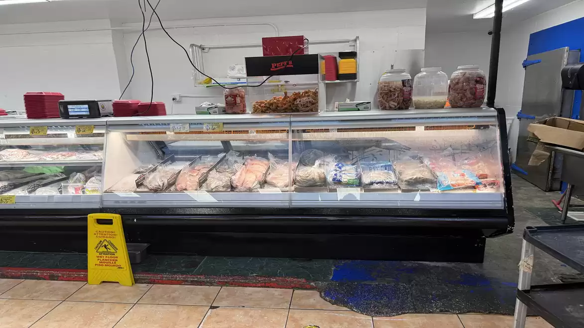 A supermarket refrigerated display case with various packaged foods and products.