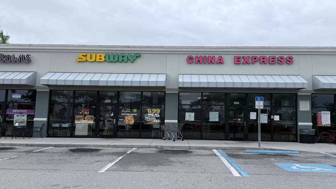 Exterior view of a shopping area with a Subway and China Express restaurant on a cloudy day.