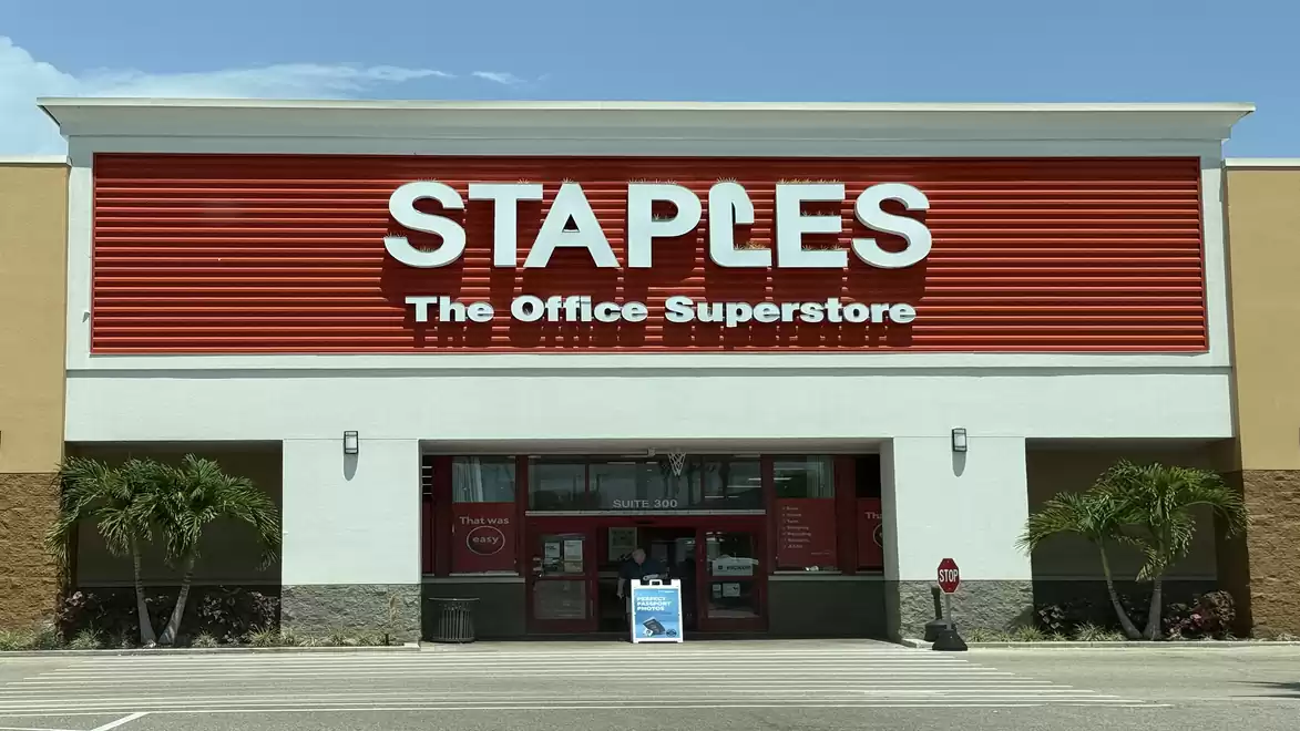 Exterior view of a Staples store with a large red company logo above the entrance.