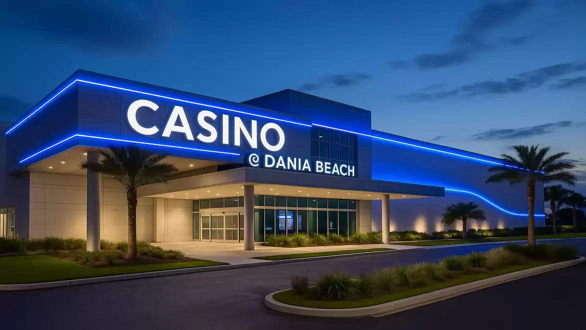 Exterior view of the Casino @ Dania Beach at night with illuminated blue neon lights.
