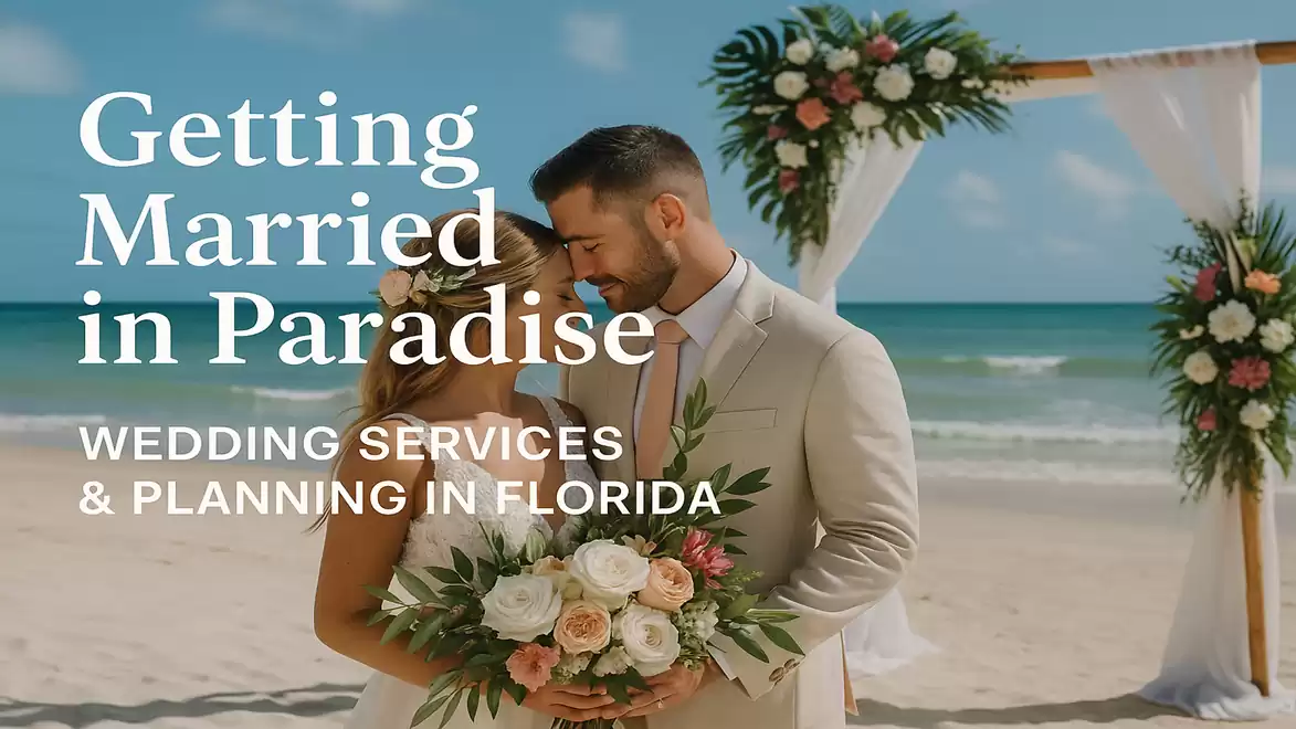 Bride and groom on the beach in front of a decorated arch with flowers, under blue skies in Florida.