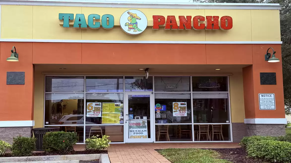 Exterior view of Taco Pancho restaurant with prominent yellow-orange sign.