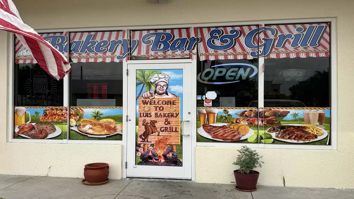 Facade of a restaurant called 'Bakery Bar & Grill' featuring a colorful storefront displaying various dishes.
