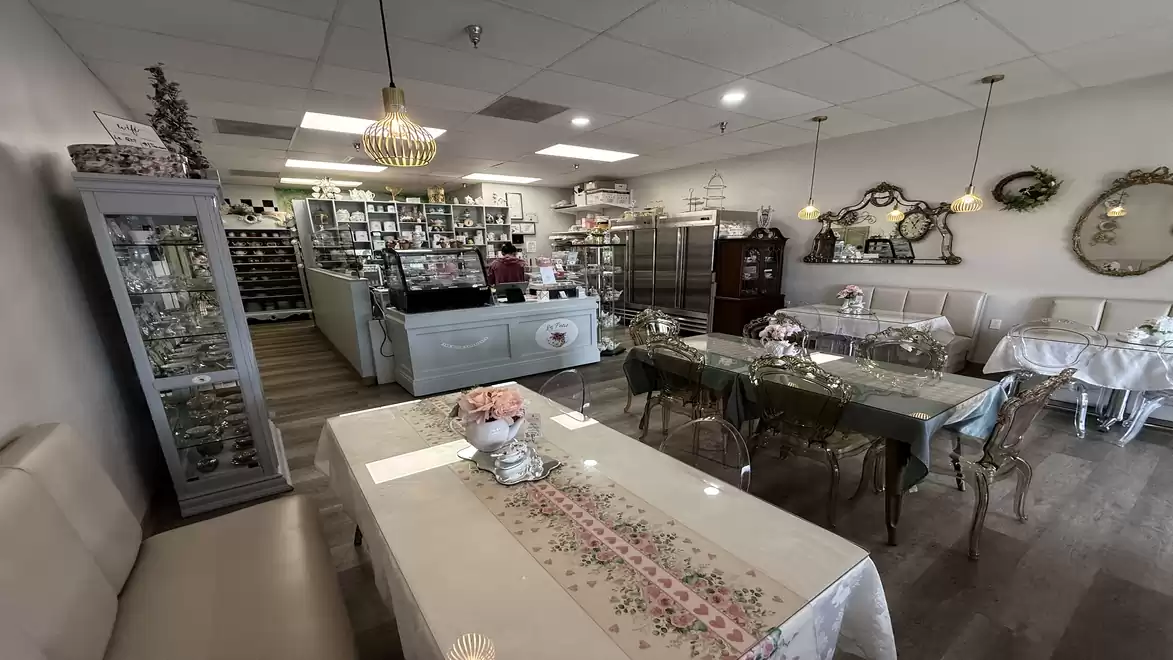 Cozy café with elegant decor, tables with lace tablecloths, and decorative wall mirrors.
