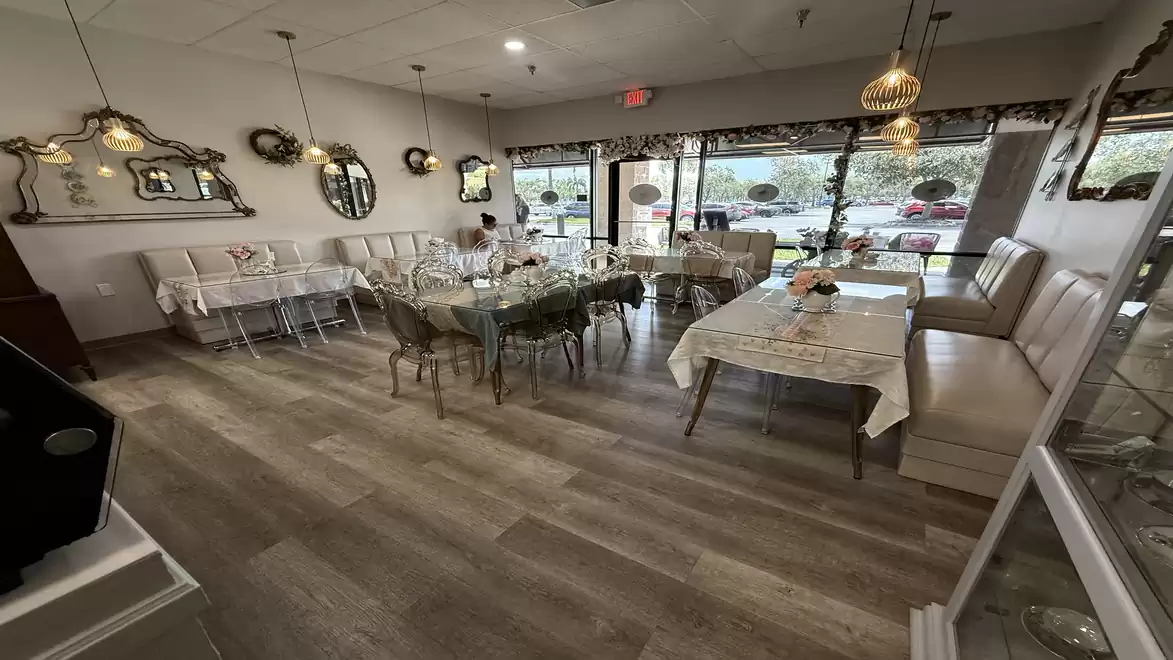 Interior of an elegant restaurant with wooden floors, stylish mirrors, and set tables.