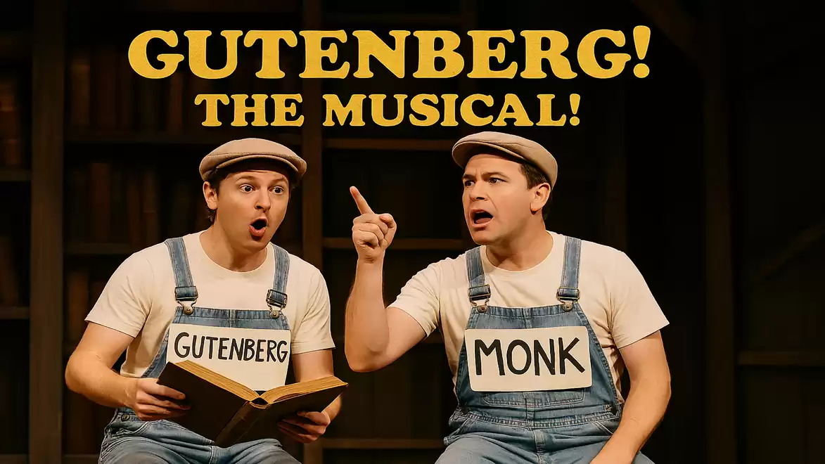 Two actors in blue overalls with name tags 'Gutenberg' and 'Monk' on the stage of 'Gutenberg! The Musical!'