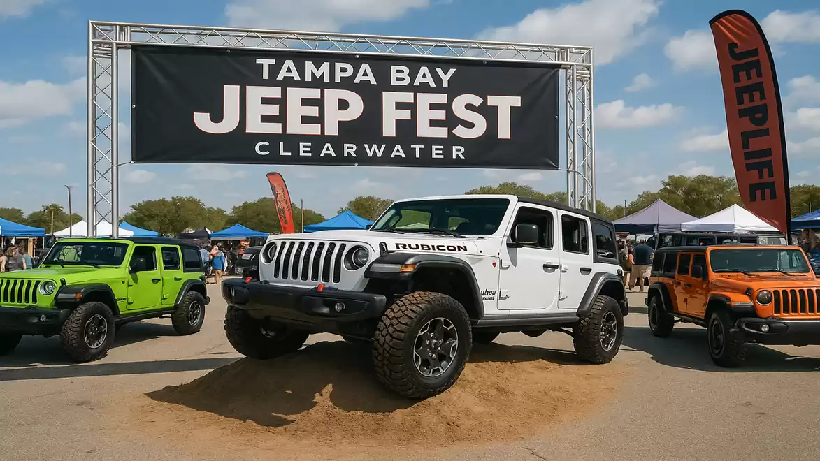 White Jeep Wrangler Rubicon parked at Tampa Bay Jeep Fest in Clearwater, surrounded by other colored Jeeps and Jeeplife banner.