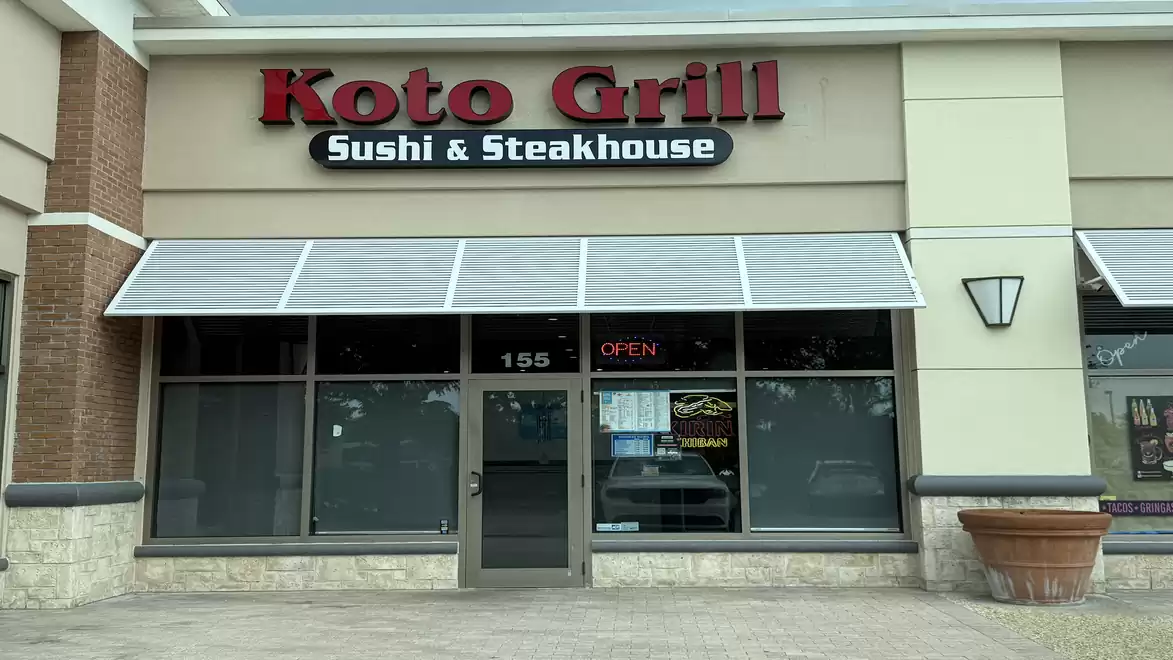 Exterior view of a restaurant named Koto Grill Sushi & Steakhouse with closed windows and an entrance door.