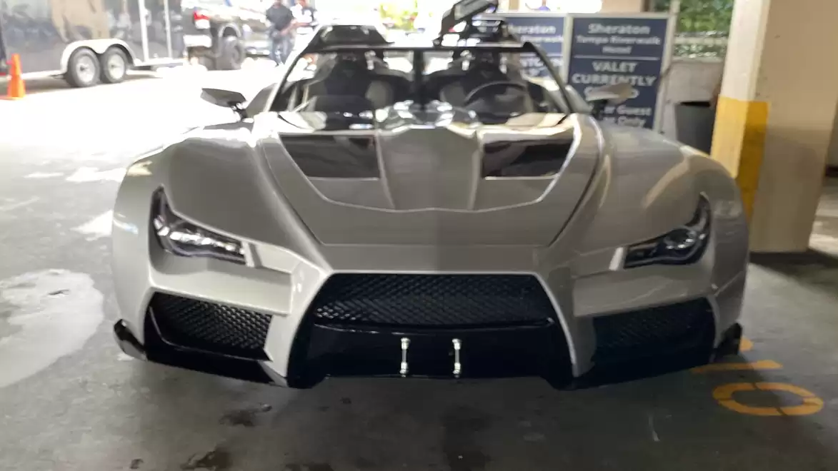 Silver sports car with futuristic design in a parking garage.