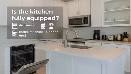Modern kitchen with open dishwasher and appliances like coffee machine and blender on the countertop.