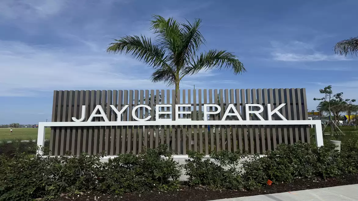 View of the entrance area to Jaycee Park with a palm tree and clear sky.