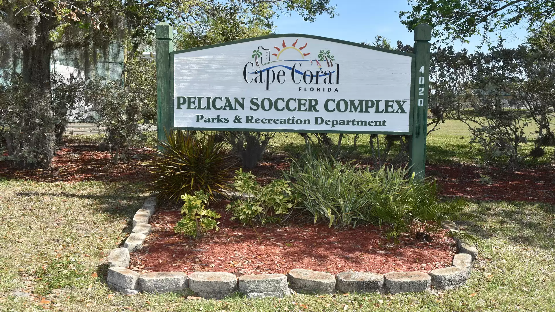 Sign of Pelican Soccer Complex in Cape Coral, Florida, surrounded by plants and stone edging.