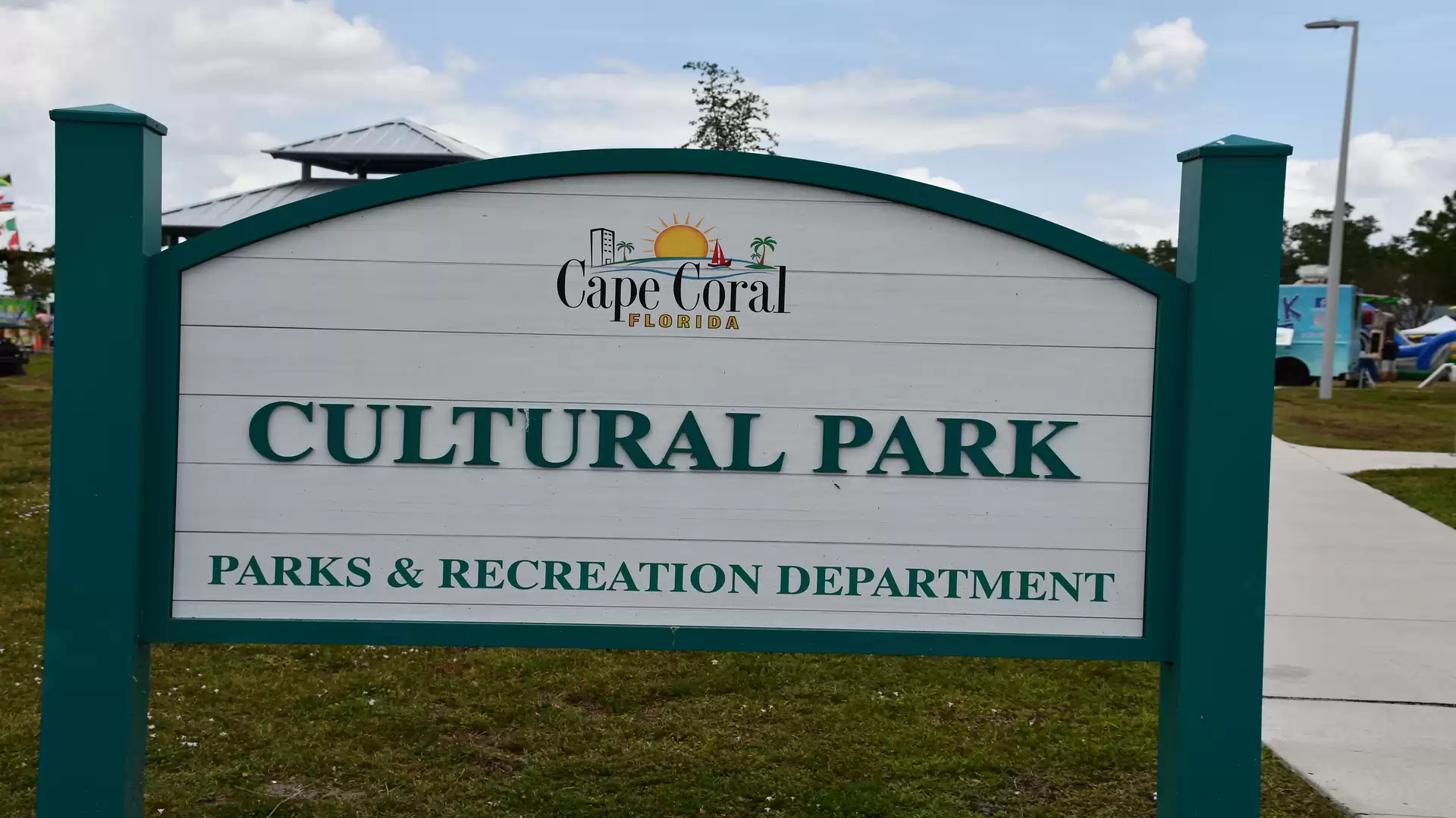 Sign in Cape Coral Cultural Park in Florida next to a walkway and green lawn.
