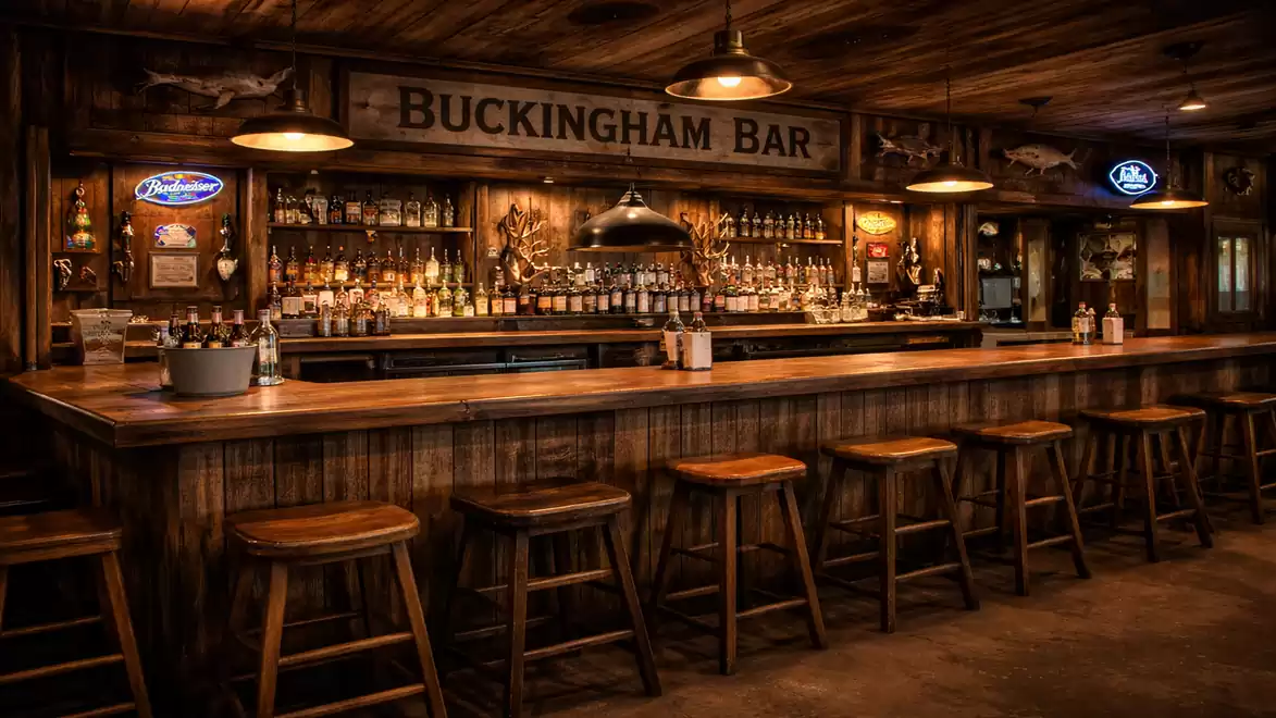 Rustic wooden bar with wooden stools and a backlit shelf full of bottles. The cozy atmosphere is enhanced by warm lighting and classic decorations.