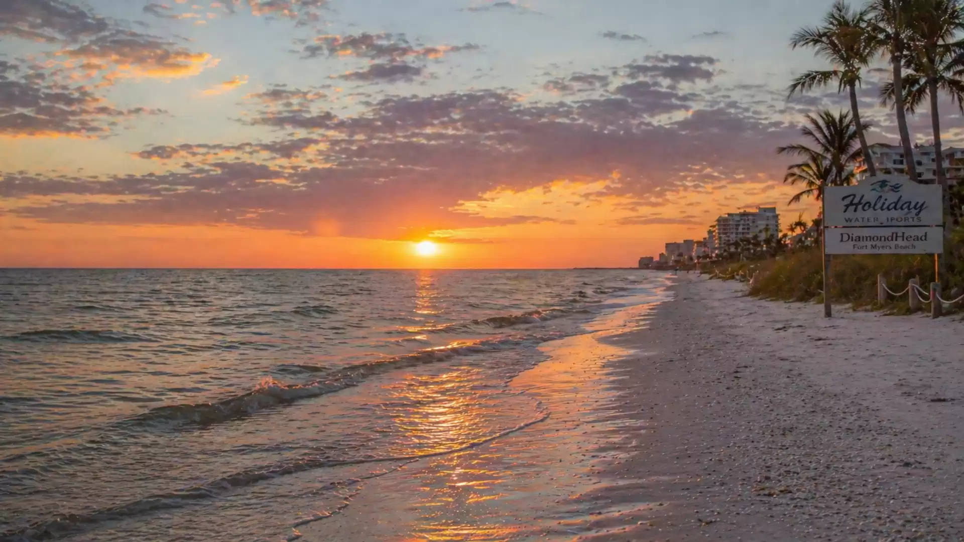 A picturesque sunset on a tropical beach with palm trees and gentle waves.