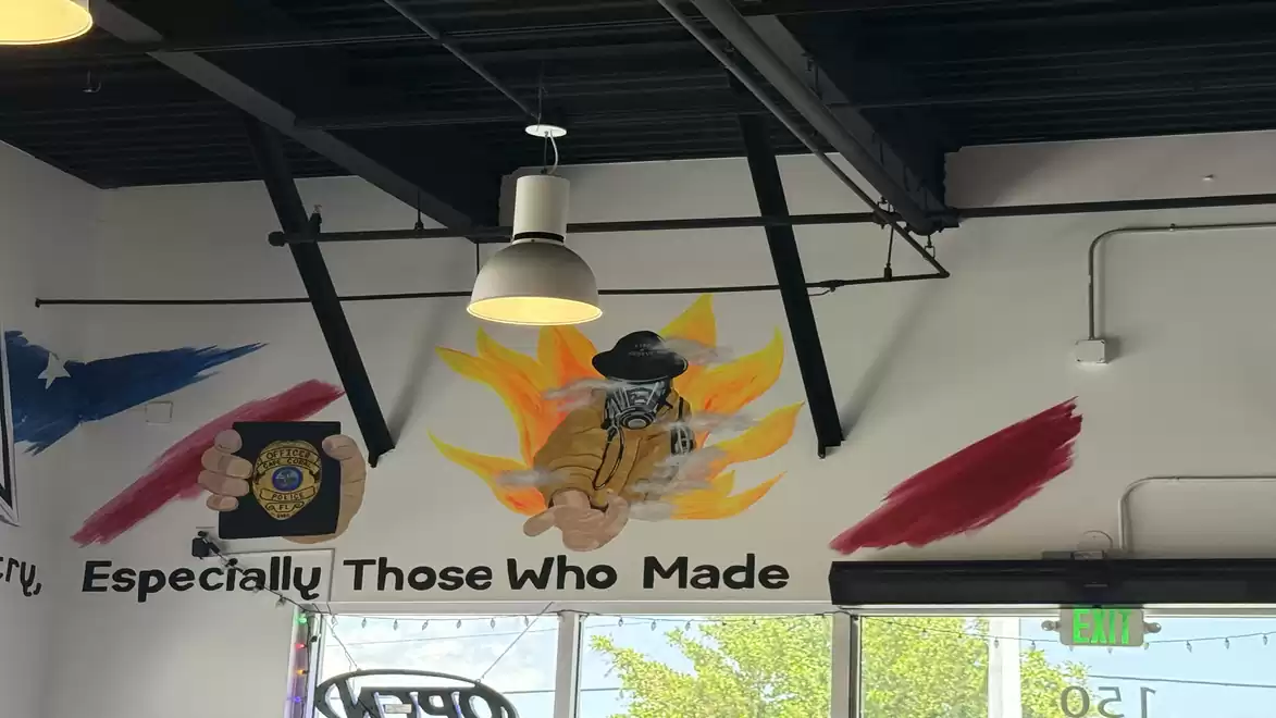 Interior of a café with a colorful wall mural featuring patriotic and artistic elements.