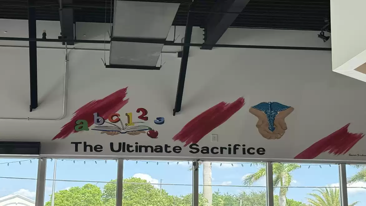 A mural with the text 'The Ultimate Sacrifice', colorful 'abc 123' letters, and an artistic design with red brushstrokes.
