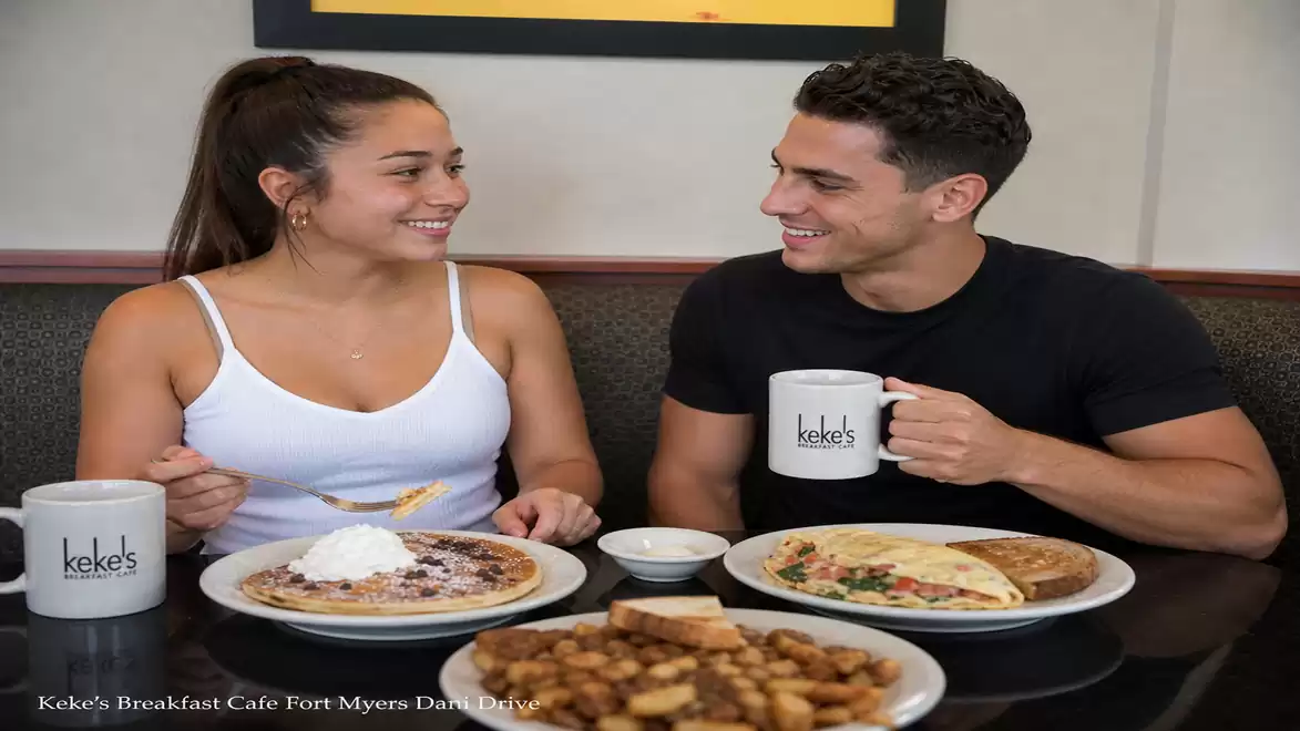 Two people sitting in a café enjoying breakfast with pancakes and omelettes.