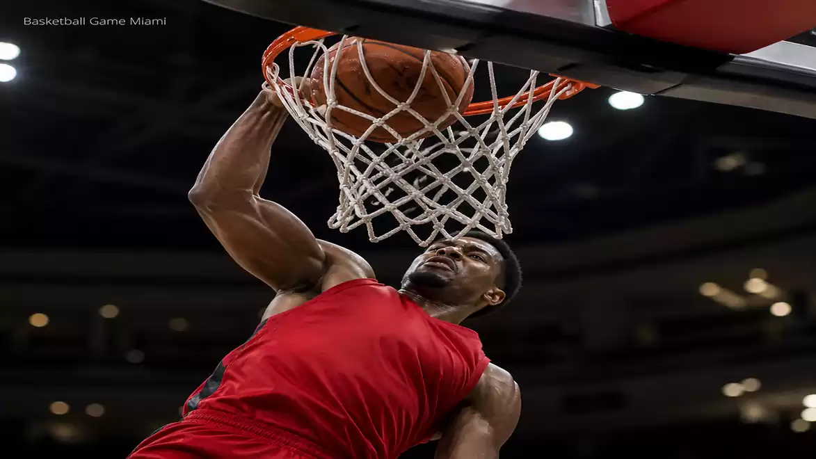 A basketball player slams the ball into the hoop during a game.