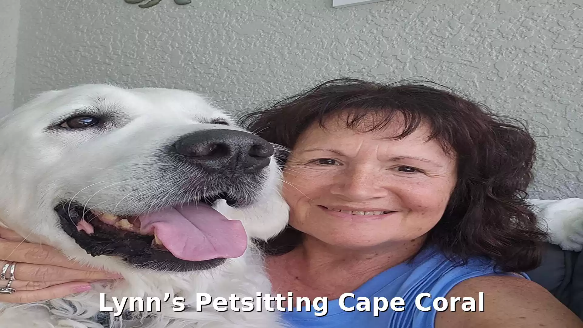 A smiling woman takes a selfie with a large white dog.