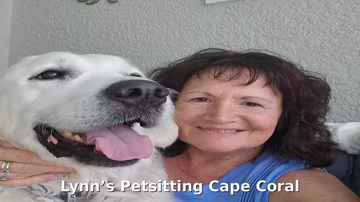 A smiling woman takes a selfie with a large white dog.