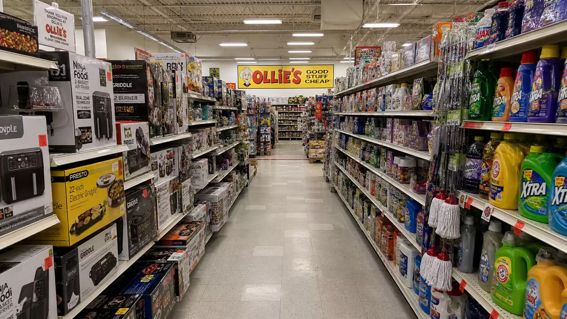 A shopping aisle in a store with various products on both sides, including household items and cleaning supplies.